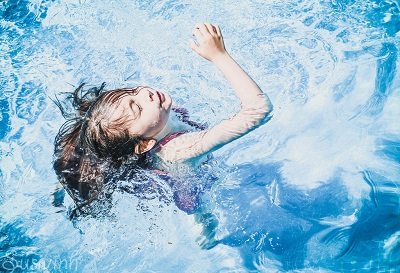 young girl swimming in a swimming pool.